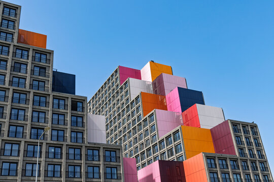 Amsterdam, Netherlands - May 23, 2026: Modern stepped building facade featuring colorful square panels against a blue sky.