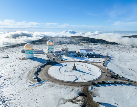 Aerial view of Torre da Serra da Estrela with its iconic radar domes and snow-covered landscape under a clear blue sky Unhais da Serra, Castelo Branco, Portugal.