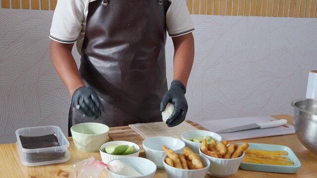 Professional sushi chef skillfully preparing maki rolls
