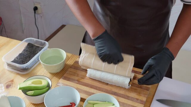 Professional chef preparing and rolling sushi maki