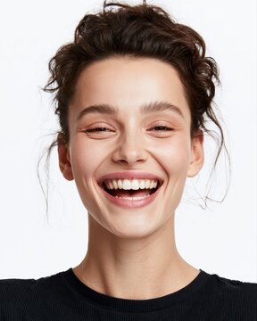 Young woman giggling and smiling brightly on white background, cheerful lifestyle portrait