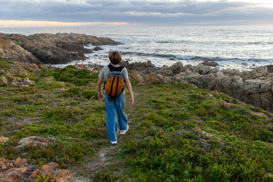 12 year old hiker on nature trail at sunset near DeKelders, South Africa
