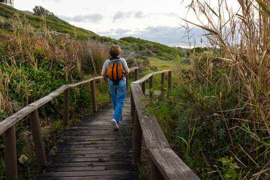 12 year old hiker on nature trail at sunset near DeKelders, South Africa