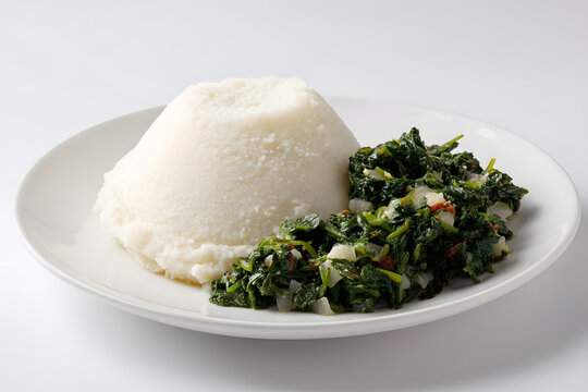Classic Ugali Served with Saut&eacute;ed Sukuma Wiki on a White Plate Against a Clean Background