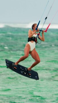  Sports woman kitesurfing in ocean in white bikini. Extreme summer sports