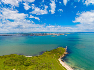 Obraz premium Beautiful view of a coastal city with blue water and green land in the daytime showing the shoreline and clouds in the sky