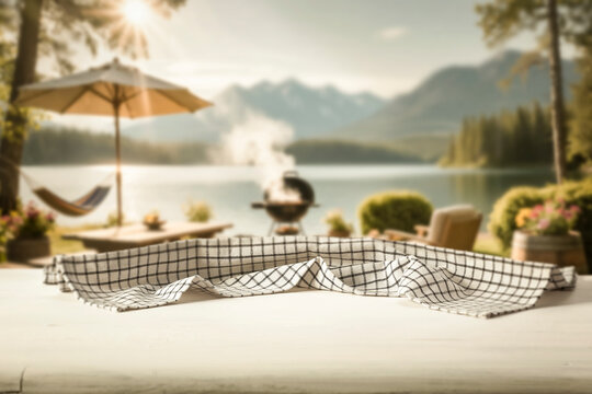 Wooden table with clean copy space for product placement and relaxing summer atmosphere with blurred summer picnic background.