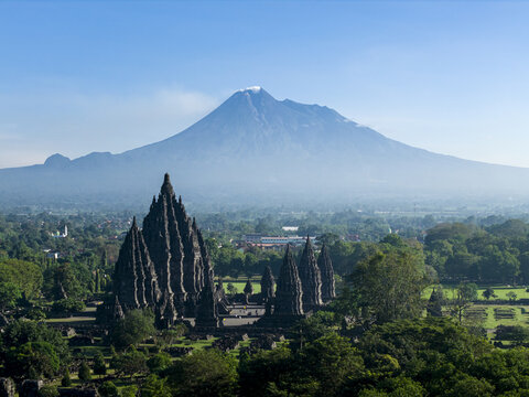 Aerial view of Prambanan Temple with the majestic Mount Merapi volcano in the background amidst lush tropical greenery Kecamatan Prambanan, Daerah Istimewa Yogya, Indonesia.