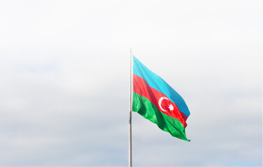 Naklejka premium Azerbaijan flag waving on a pole against a cloudy sky background with vibrant colors