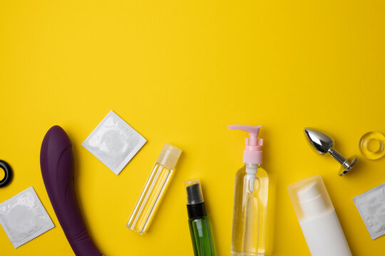 Intimate lubricant and sex toys on a colored background
