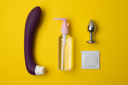 Intimate lubricant and sex toys on a colored background