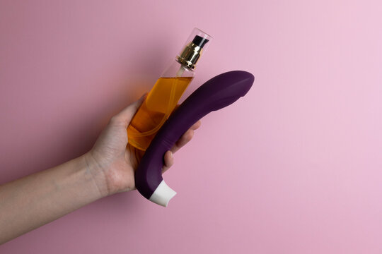 intimate lubricant in hands on colored background