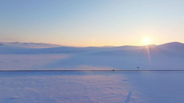 Snowy Road Through Winter Hills at Sunrise