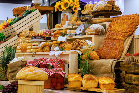 Variety of bread pastries are arranged on wooden crates at local market.