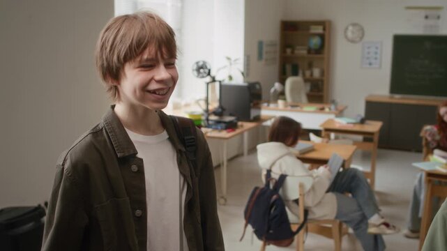 Teenager boy tapping his friend by shoulder before shaking his hand, meeting before 3D modelling class in modern school