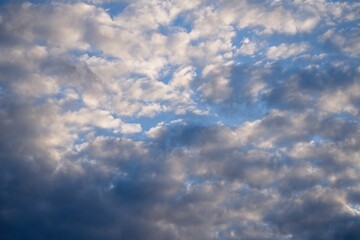 Obraz premium Spring sky with cumulus clouds and dark clouds. 