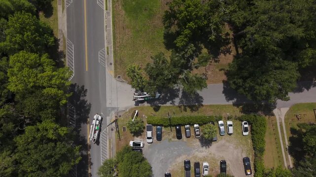 Two electrical utility trucks with lifts, driving on rural road arriving