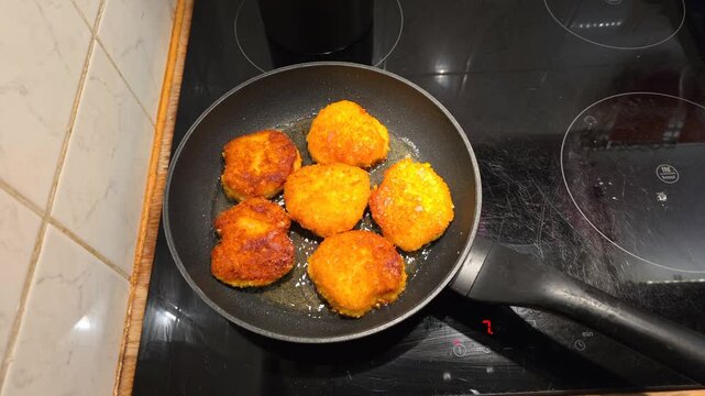 Cooking breaded meat in frying pan on stove, natural sound