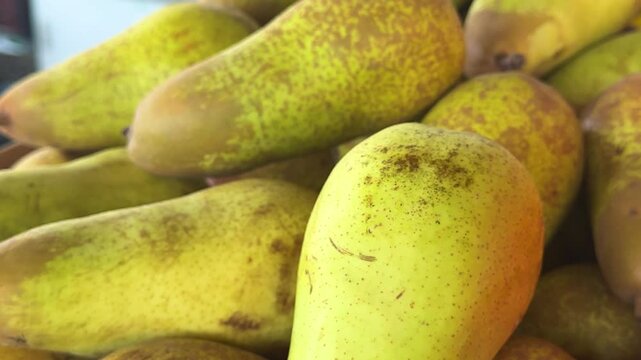 Ripe winter pears displayed on market counter with natural smooth texture and organic fresh fruit atmosphere for healthy grocery shopping.