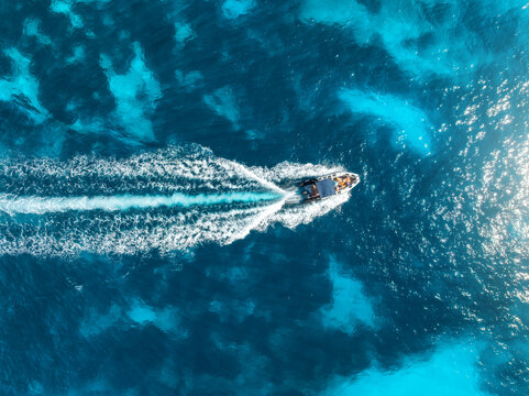 Aerial drone view of beautiful floating boat in blue sea on sunny day in summer. Mallorca island, Spain. Top down view of boat, sea, turquoise water. Travel. Tropical landscape. Yachting. Cruise