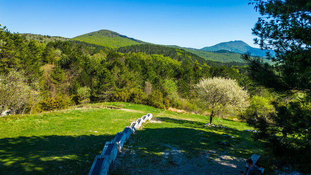 Vibrant spring day in Ucka Nature Park, Croatia. Lush green mountains, blooming trees, and clear skies offer a perfect escape. A serene moment captured from above. Brgucka korita