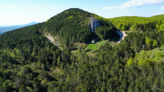 A runner navigates the vibrant green trails of U?ka Nature Park, Croatia, under bright afternoon sun. Lush forests and clear skies define this scenic adventure. Brgucka korita