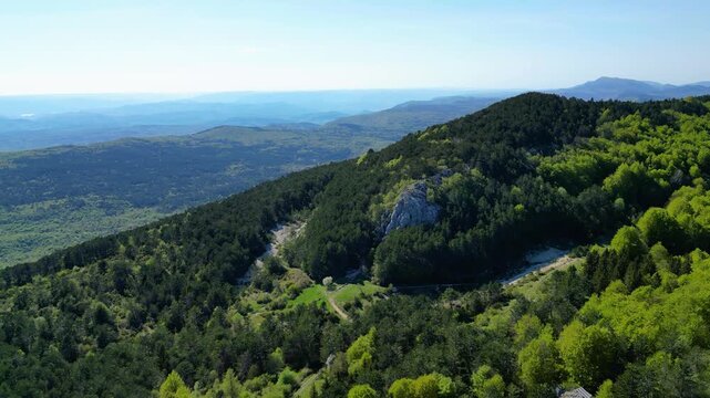 Aerial view of Ucka Nature Park in spring, showcasing lush forests and rolling hills under a clear blue sky. A pristine natural escape in Croatia.