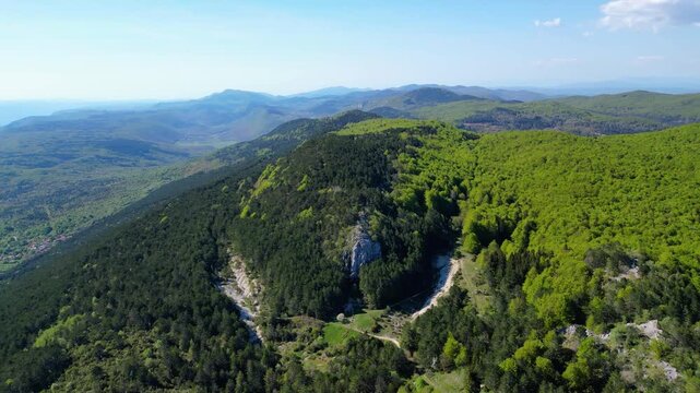 Aerial view of Ucka Nature Park in spring, showcasing lush forests and rolling hills under a clear blue sky. A pristine natural escape in Croatia.