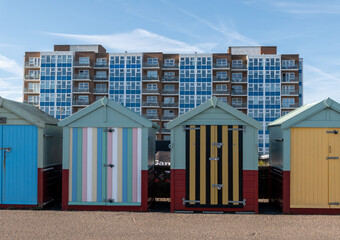 Hove beach huts on the promenade with high rise flats in the distance © yackers1