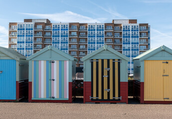 Hove beach huts on the promenade with high rise flats in the distance © yackers1