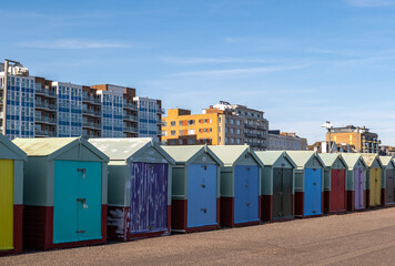 Hove beach huts on the promenade with high rise flats in the distance © yackers1