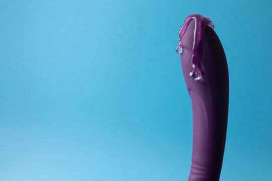 Sex toy with intimate lubricant on a colored background