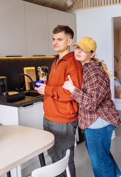 Young Couple Hugging In Modern Cabin Kitchen During Slow Morning Together