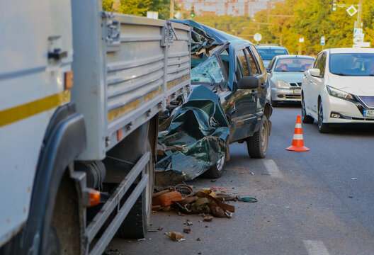 Severe collision between passenger car and utility truck on city street