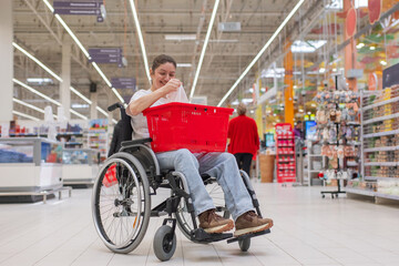 Obraz premium A Caucasian woman in a wheelchair buys fruit at a supermarket.