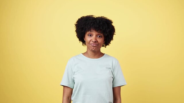African american woman expressing doubt and indecision on yellow background