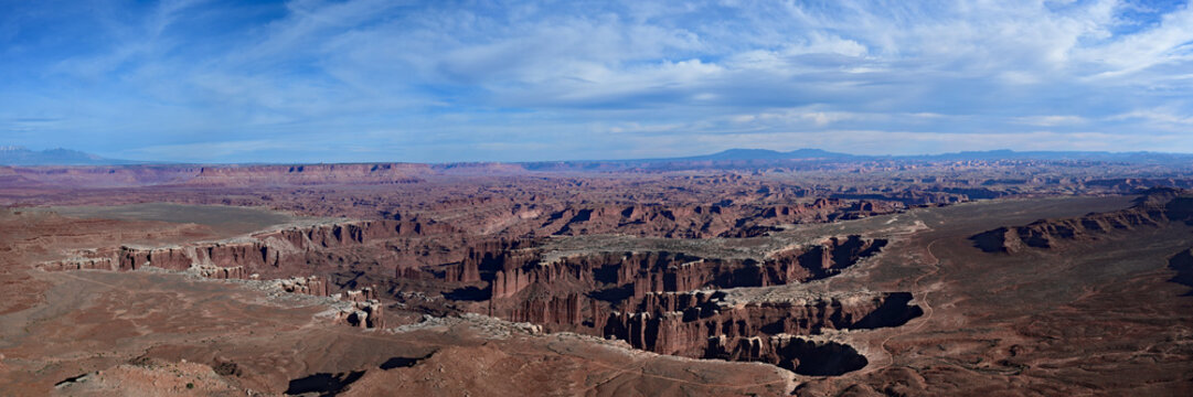 Panoramic view of canyons in vast expanse of land in Canyonlands National Park, Utah carved by Green and Colorado Rivers under dramatic spring clouds.
