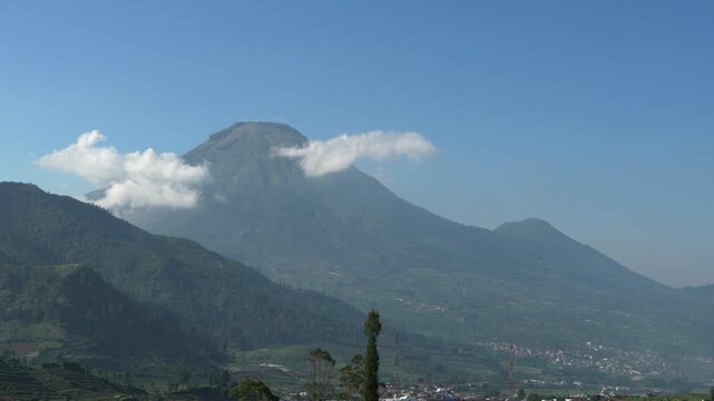 Scenic time-lapse of beautiful volcanic peak with fast-moving clouds in Dieng plateau area, majestic Indonesian nature landscape.