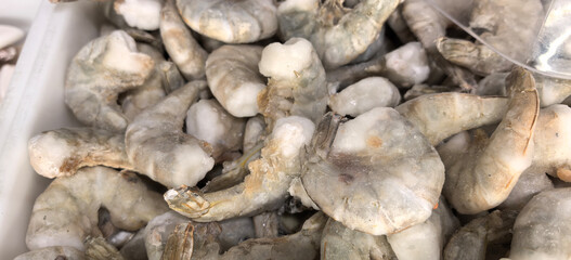Fototapeta premium Fresh shrimp being prepared for sale at a local market during the morning hours