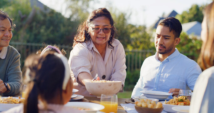 Serving, generations or Asian family at table with meal, bonding together or reunion in healthy relationship. Grandparents, parent and child outdoor with feast, connection or shared food in tradition