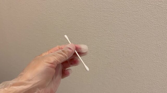 滅菌綿棒を開封する手