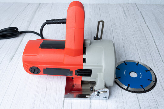 red electric saw on wooden table.