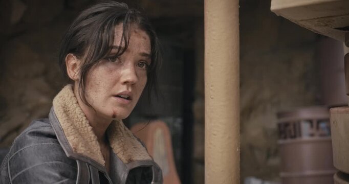 Young female adventurer bound to pole and talking to someone in sci-fi area - closeup
