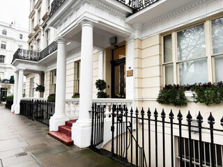 Fototapeta premium Elegant white terraced Beaumont House Hotel facade with columns and black railings in London, UK residential street