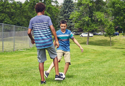 Children, boys and play with soccer ball at park for fun, bonding and outdoor on summer vacation. Kids, friends and happy with football, dribble or contest with skill, games and kick at playground