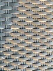 Obraz premium Detailed woven rattan texture illuminated by warm natural sunlight, showcasing intricate patterns and organic material for interior, furniture, and abstract design concepts. 