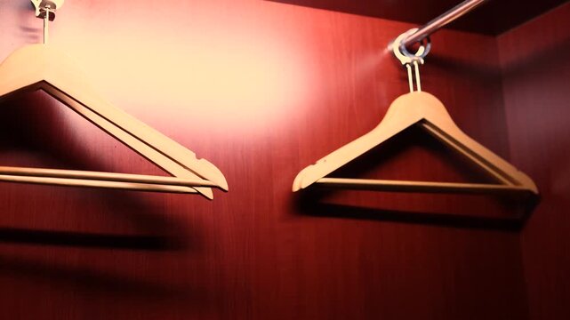Empty clothes hangers in warm light wardrobe interior hotel closet concept