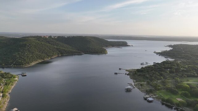 Flying towards a big hill to reveal a full Lake Travis, one of the Highland Lakes of central Texas. 