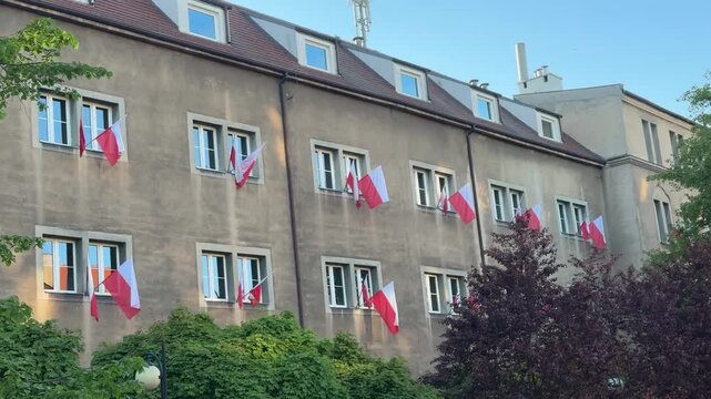 Many polish flags hanged outside from the house windows. Patriotism in Poland, national holidays celebration, flag day, constitution day, eastern european country political symbol