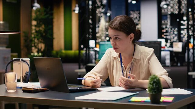 Frustrated entrepreneur ripping torn paper after finding bad typo in her research notes, at night in modern workspace. Businesswoman faces stress from overtime work, reflecting disappointment.